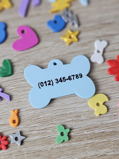 Two-sided bone tag showing a phone number on the back