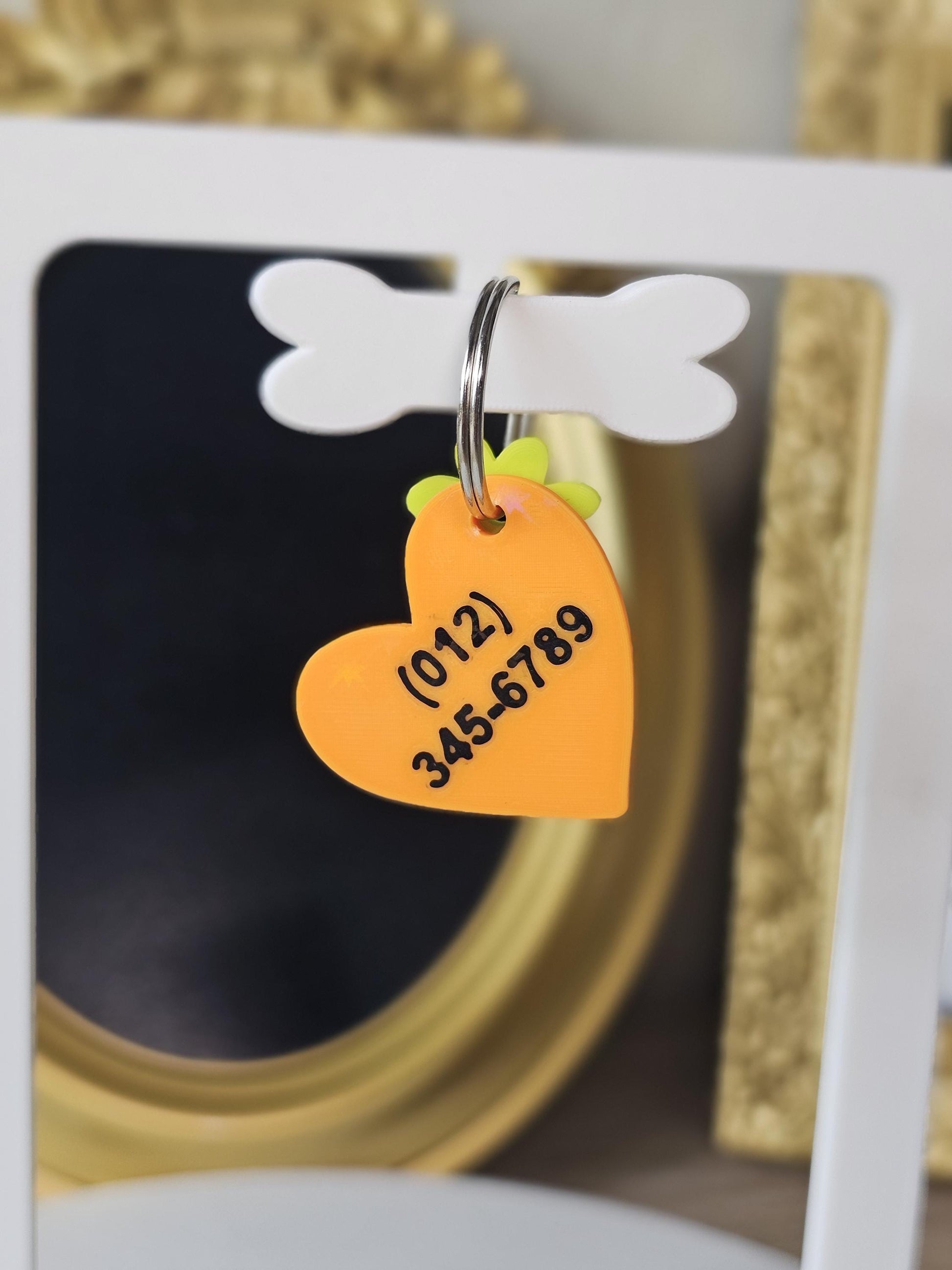 Two-sided heart tag showing a phone number on the back