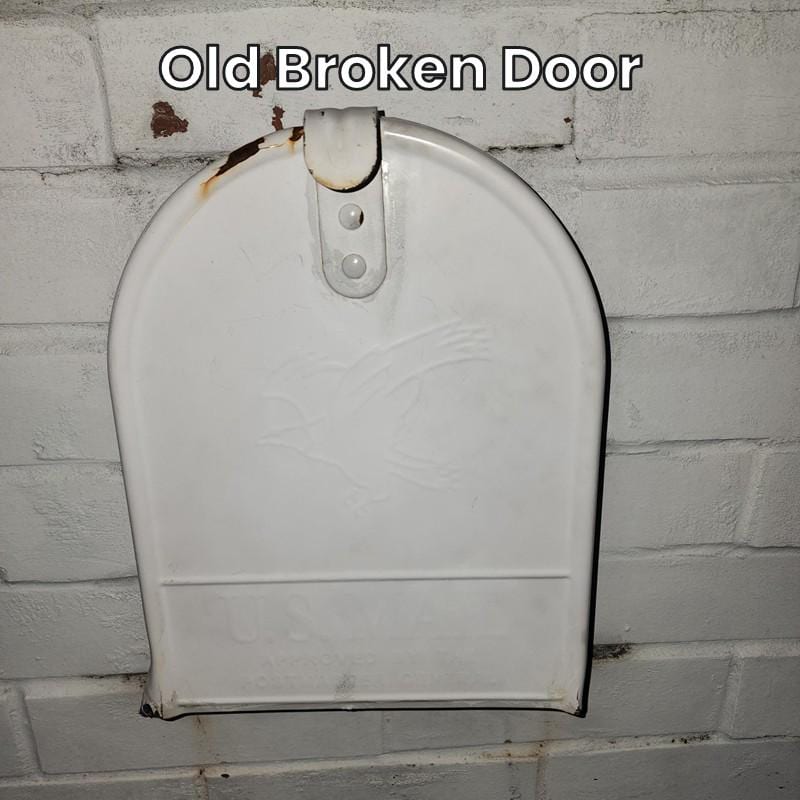 Old broken door on a white medium metal mailbox
