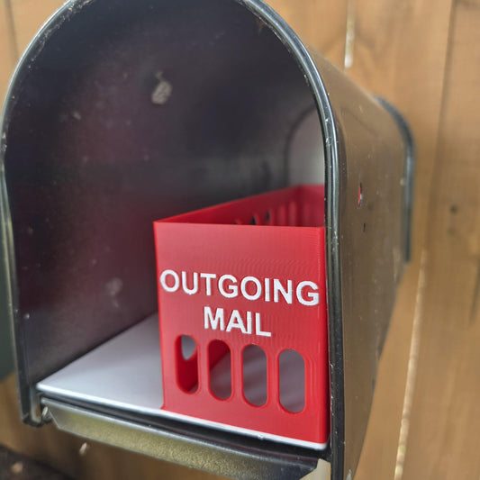 Red outgoing mail bin with OUTGOING MAIL lettering inside a mailbox