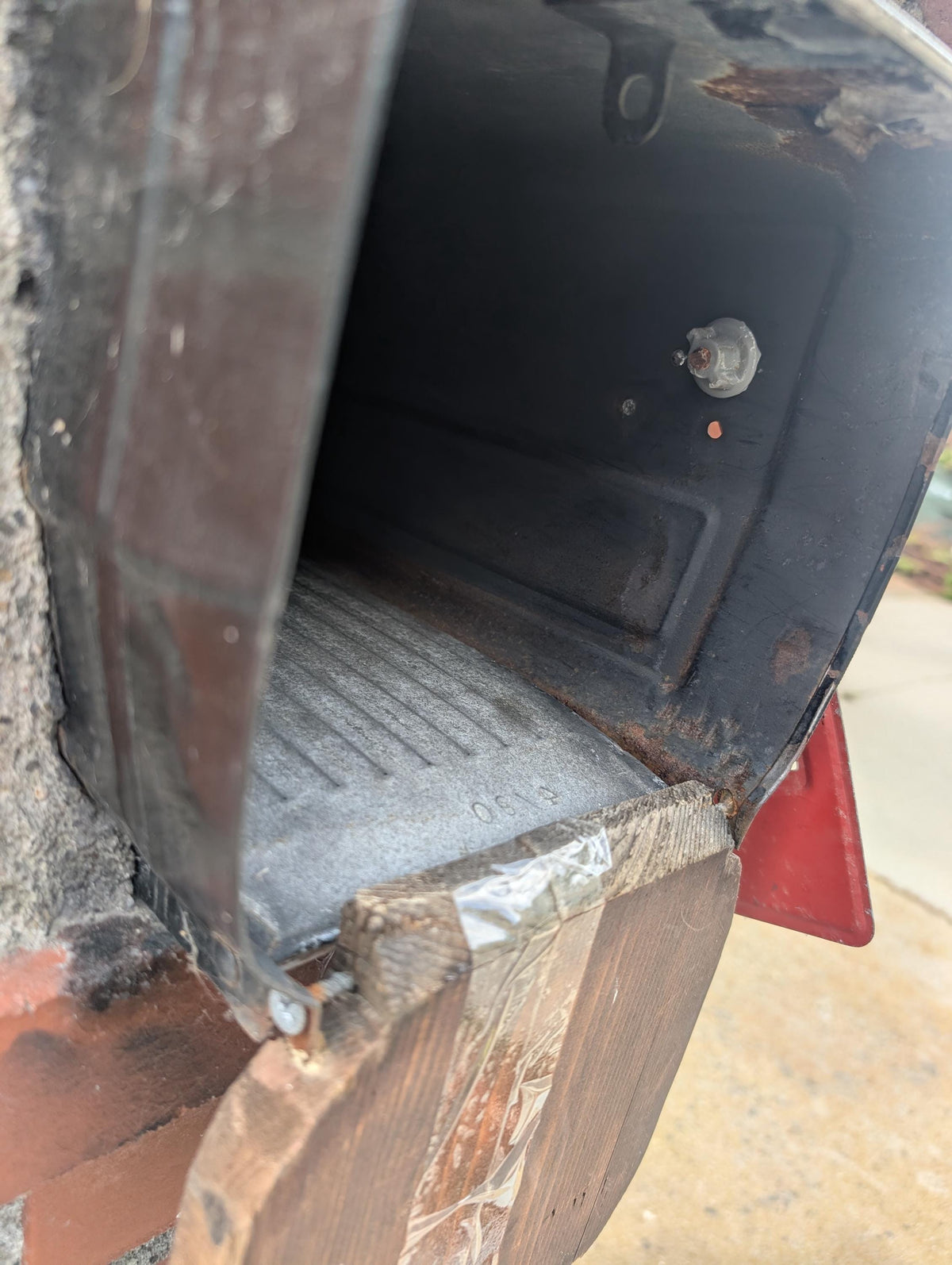Side view of the open square metal mailbox and hinge area